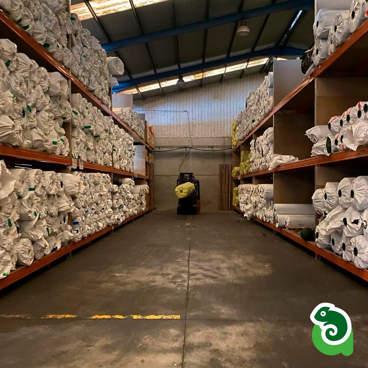 Rollos de césped artificial almacenados en estanterías